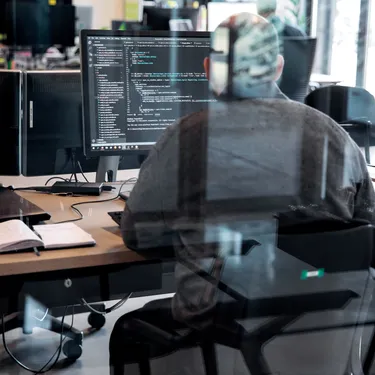 men-working-behind-screen-with-reflection